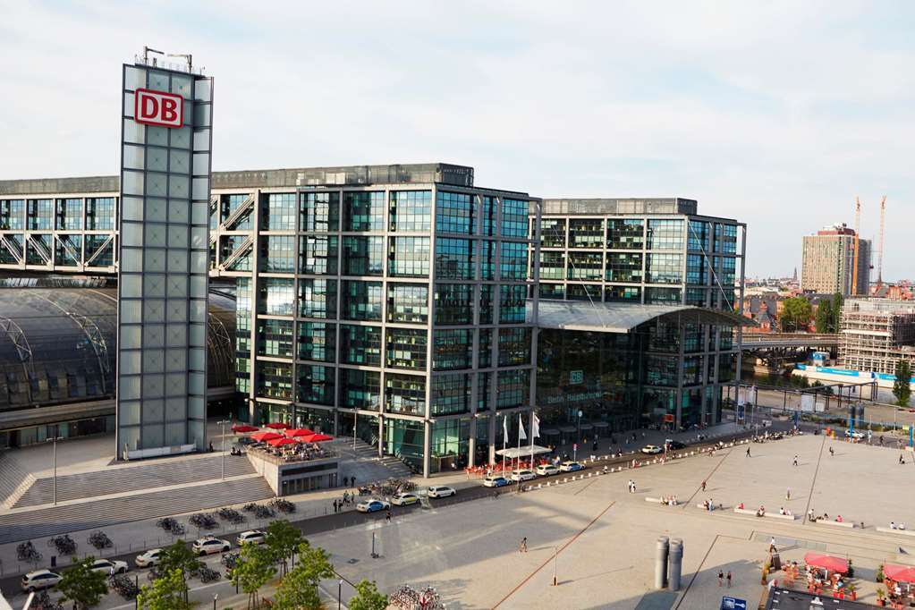 Steigenberger Hotel Am Kanzleramt Берлін Екстер'єр фото The photo shows a modern railway station building, characterized by large glass facades and a distinctive architectural design. There is a tall structure on one side marked with "DB," indicating it's part of the German railway company, Deutsche Bahn.